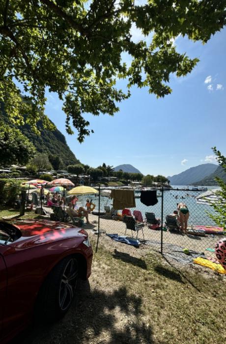 Ingresso al molo di Camping Darna, con vista sul lago e montagne verdi.