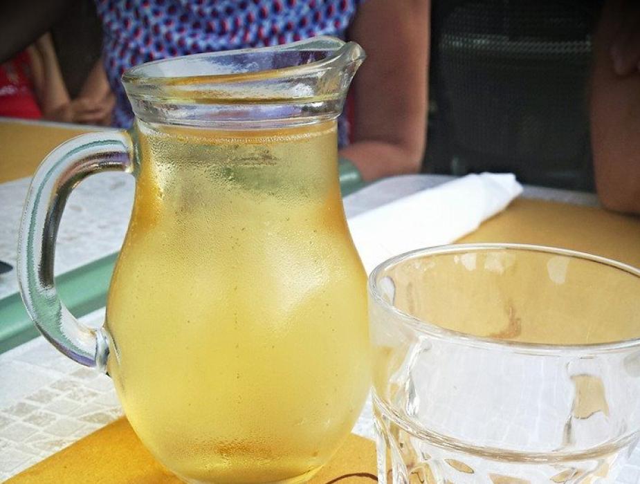 Caraffa di vino bianco su tavola di ristorante italiano con tovaglietta.