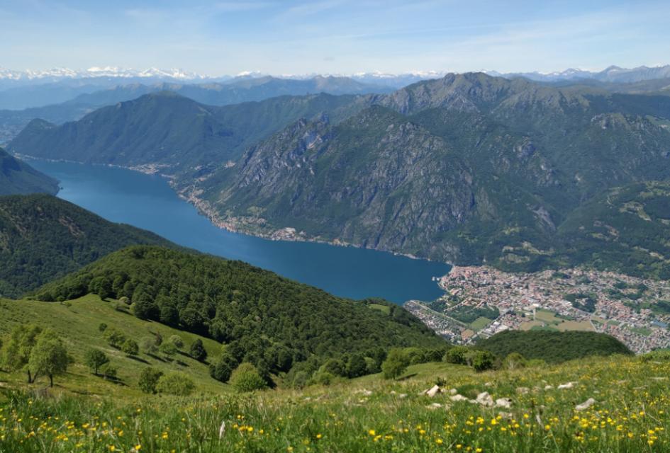 Vista aerea di un lago alpino circondato da montagne e villaggi pittoreschi.