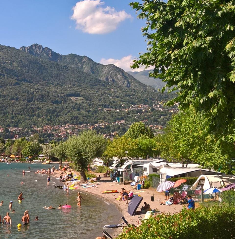 Vista aerea di un villaggio costiero con case e barche su un lago.
